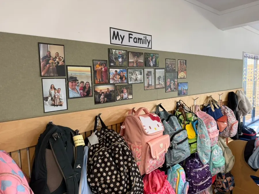The family photo wall above the bag hooks in a Northcross room.