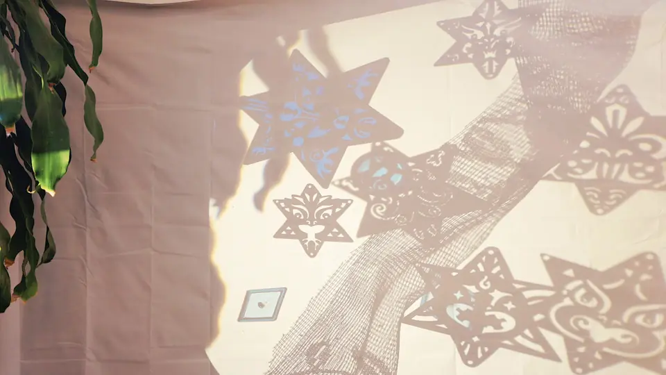 Paper stars on a wall, with a pattern projected across them.