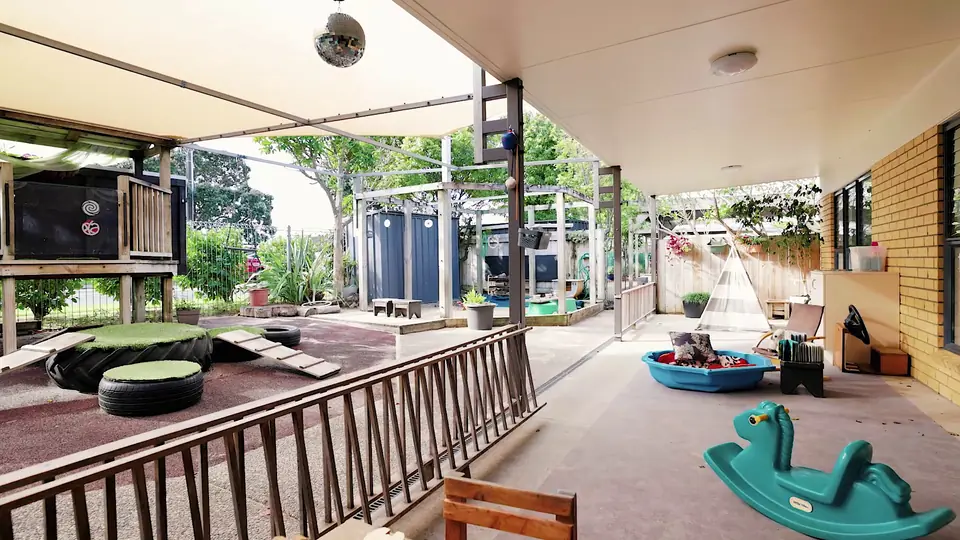 The covered deck with tyres, rocking horses and the playground beyond.