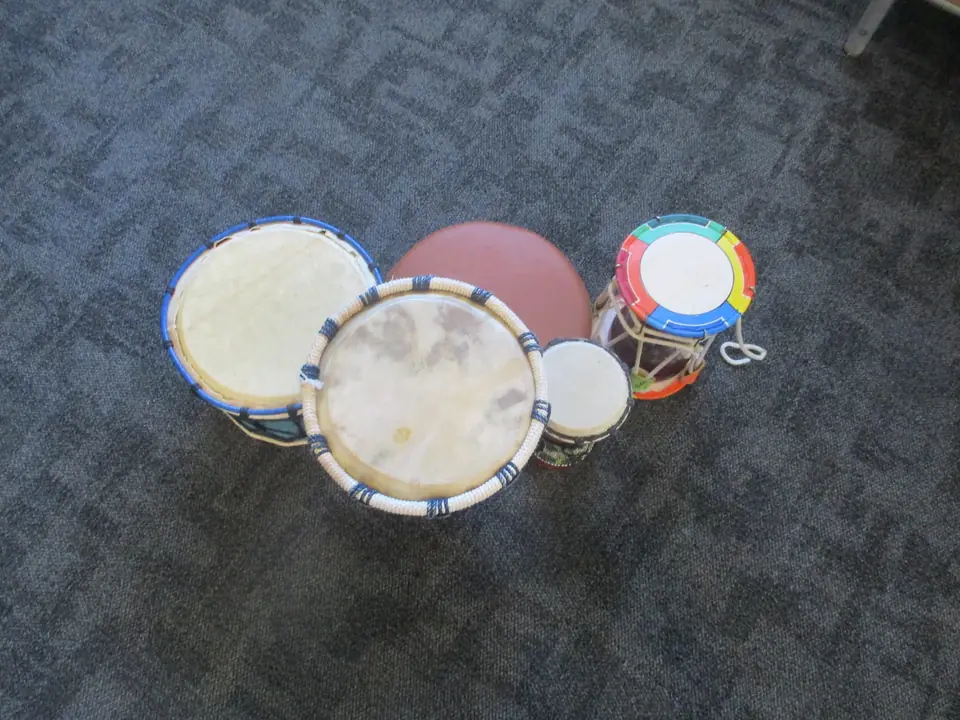 Hand drums of different sizes on the carpet.